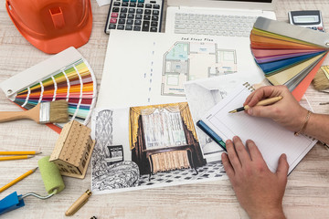 Top view of architects  drawing modern house with sample material, hardhat, laptop on creative...