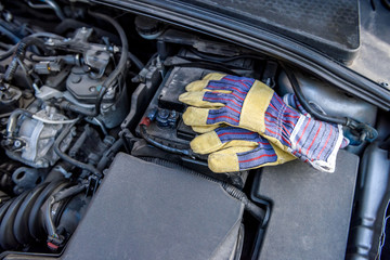 Fototapeta na wymiar Protective gloves with spanners at car engine