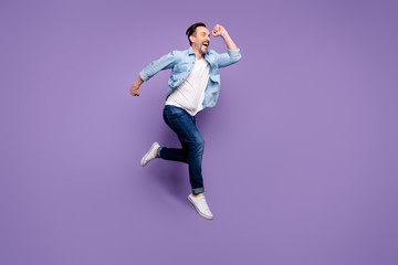 Full length profile side photo of crazy funky funny man jump run after black friday sales want hurry buy presents wear good looking outfit isolated over violet color background
