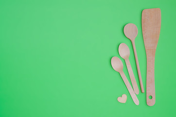Disposable tableware set from natural materials, wooden spoon, Eco-friendly. Wooden spoons Eco concept on green background. Copy space. Eco pine wood spoons. 