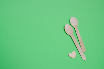 Disposable tableware from natural materials, wooden spoon, Eco-friendly. Wooden spoons Eco concept on green background. Copy space. Eco pine wood spoons. Disposable tableware made of natural materials