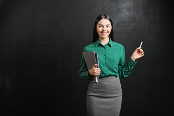 Female teacher near blackboard in classroom