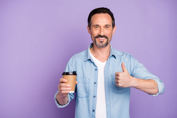 Portrait of positive cool man promoter have weekends get take-out coffee cup enjoy show thumb up recommend tea mug ad wear stylish clothes isolated over violet color background