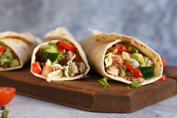 Burrito - mexican dish with corn tortilla, jasse, vegetables and sauce. Tortilla stuffed.