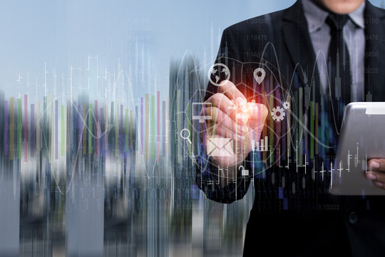 Businessman using tablet with interface finance graph of stock market on city background.