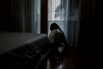 Sad young woman sitting on the bed in the bedroom, People with depression concept. - obrazy, fototapety, plakaty