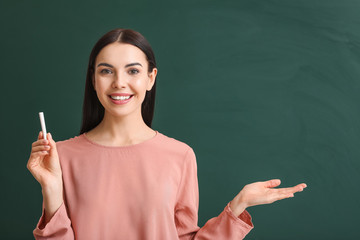 Female teacher near blackboard in classroom