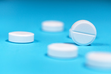 white tablets close-up on a blue background. selective focus. concept of medicine