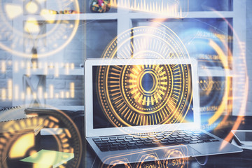 Computer on desktop in office with technology theme hologram. Multi exposure. Tech concept.