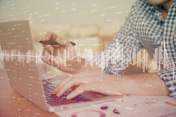 Multi exposure of forex graph with man working on computer on background. Concept of market analysis.