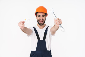 Happy young man holding credit card and wrench.