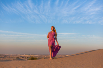 Fototapeta na wymiar Blonde model in the desert at Emirates