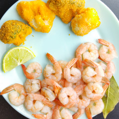shrimp with lemon and broccoli on a blue plate close-up. broccoli AU gratin.