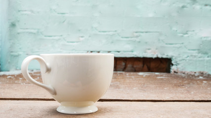 White cup on wood table.