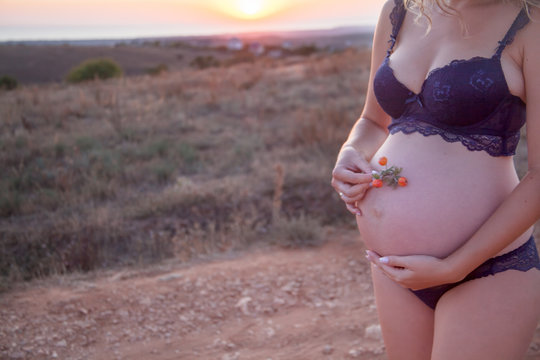 Pregnant Woman In Panties And A Heart-patterned Bra Is Standing Indoors  With A Potted Flower. Stock Photo, Picture and Royalty Free Image. Image  126882897.