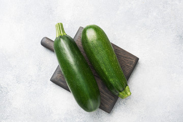 Fresh green zucchini on a cutting Board. Concrete grey background. Copy space.