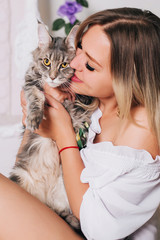 Beautiful girl in a white shirt hugs a fluffy cat. Favorite Pets