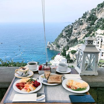 Breakfast Served On Table At Restaurant With Sea In Background