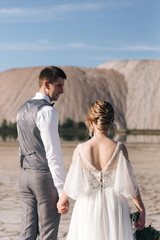 Beautiful elegant couple of newlyweds in love on a beautiful natural background of salt mountains and quarries