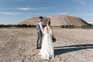 Beautiful elegant couple of newlyweds in love on a beautiful natural background of salt mountains and quarries