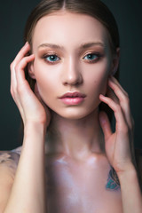 Fototapeta na wymiar Studio portrait of a model. Body art gray roses. Beautiful girl on gray background