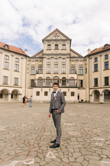 Fototapeta premium Portrait of the groom on the background of an old building