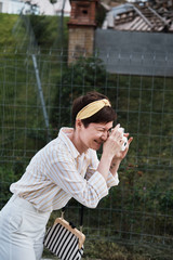 Woman with polaroid taking picture outdoor