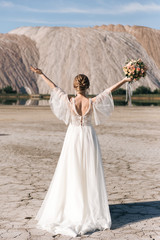 Beautiful elegant bride on the background of salt sand quarries