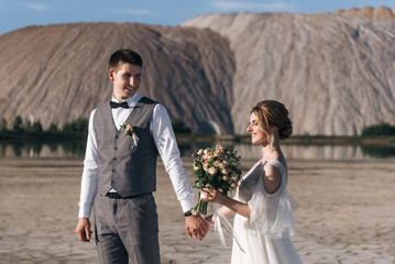 Beautiful elegant couple of newlyweds in love on a beautiful natural background of salt mountains and quarries