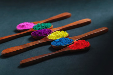 Indian Festival Holi , Colors in wooden spoon on dark background 