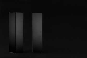 Rectangle tall black paper boxes - side view, front view on dark black background, mock up of...