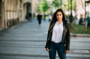 Fototapeta premium Beautiful fashion model in black leather jacket posing outdoor.
