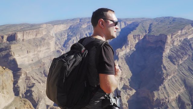 Young Foreign Male Tourist Enjoying the View of Wadi Ghul aka Grand Canyon of Oman in Jebel Shams Mountains. Man in Active Solo Travel in Middle East Countries