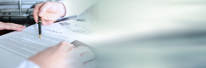 Dealer showing a detail of a car purchase contract; panoramic banner