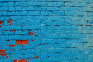 Blue brick wall with couple of orange bricks