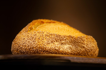 Hot sesame seed bread on wooden cutting board