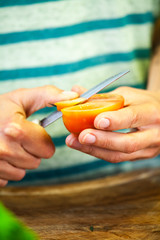 Woman cuts the tomato
