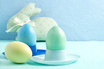 Easter eggs and a rabbit in the background on a blue background.
