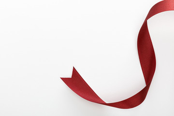 top view of satin burgundy decorative curved ribbon isolated on white