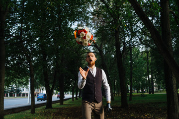 Comic moment of groom catching bridal bouquet with his mouth open