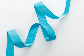 top view of blue decorative curved ribbon on white