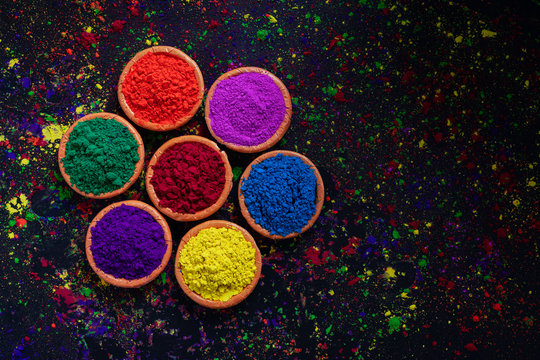 Indian Festival Holi, Colors in wooden bowl on dark background © PRASANNAPIX