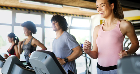 Fototapeta premium Group of people exercising in a gym cardio training and running