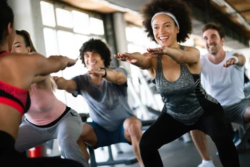 Fotobehang Fitness Groep gezonde fitte mensen in de sportschool die aan het trainen zijn
