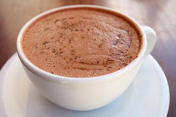 Closeup a cup of mouthwatering hot chocolate on wooden table