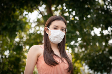 Woman wearing the N95 respiratory protection face mask, protect pollution (PM2.5), smog and viruses.