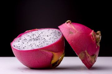 Evenly lit opened up white-fleshed Pitaya or Dragon fruit with the outer skin and also white pulp...
