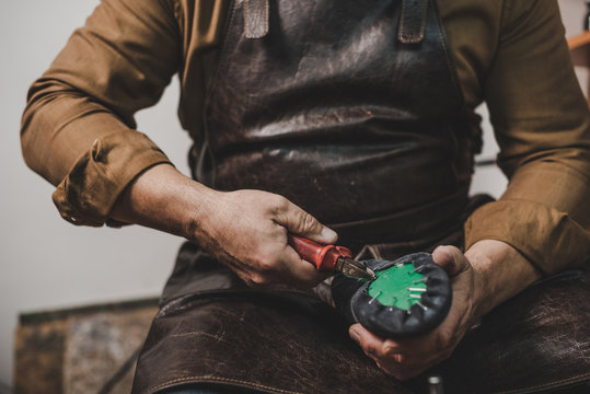 cropped view of cobbler removing nails from shoe with pliers