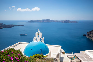 Fantastic travel background. Famous travel and vacation destination in Santorini, Fira. Church and dome with beautiful sea view. Summer landscape and seascape.