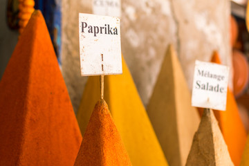 Paprika powder on a spice market. Organic ingredients for cooking healthy food with red pepper. Translation: Paprika; Salad mix.